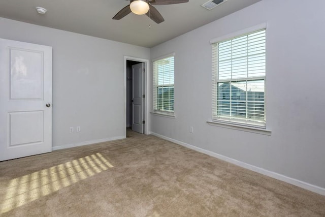 carpeted spare room featuring ceiling fan