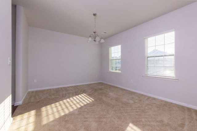 empty room featuring a notable chandelier and carpet