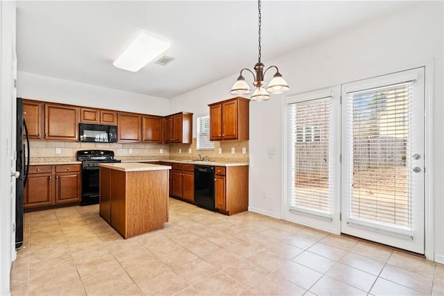 kitchen with brown cabinets, black appliances, light countertops, and backsplash