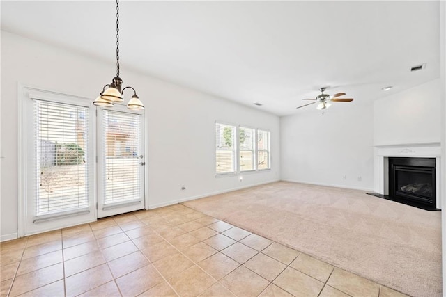 unfurnished living room featuring ceiling fan, light tile patterned floors, light carpet, a fireplace, and visible vents