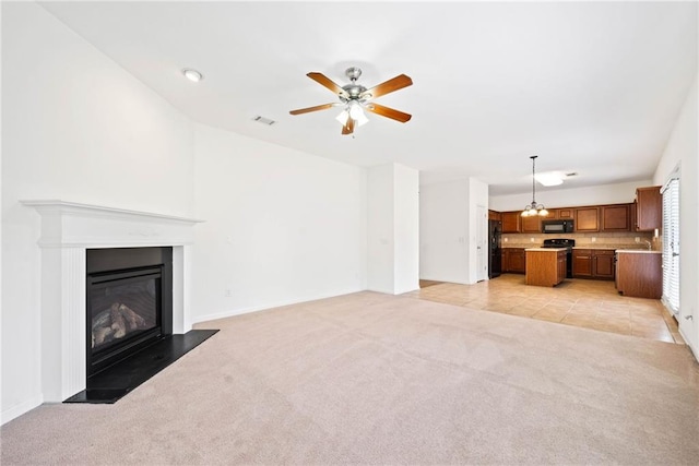 unfurnished living room featuring light carpet, light tile patterned floors, visible vents, a ceiling fan, and a glass covered fireplace