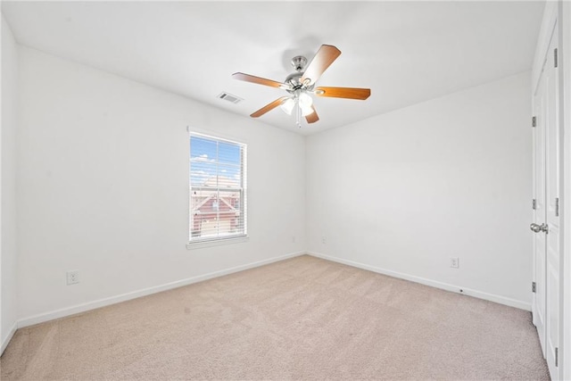 spare room featuring light carpet, baseboards, visible vents, and a ceiling fan