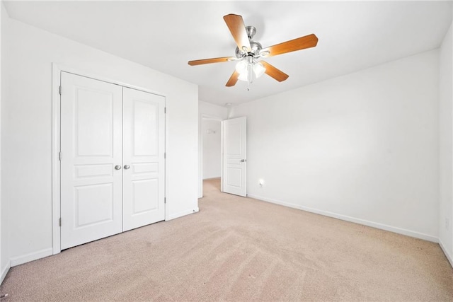 unfurnished bedroom with light carpet, baseboards, and a closet