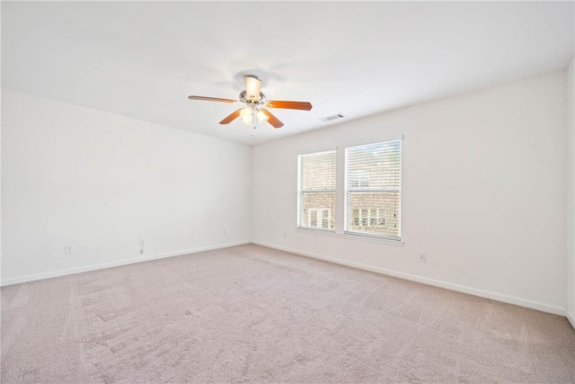 spare room featuring ceiling fan, carpet, visible vents, and baseboards