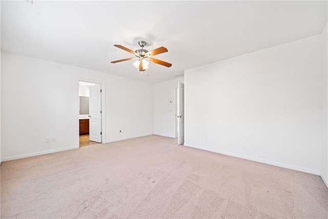 empty room featuring a ceiling fan, light carpet, and baseboards