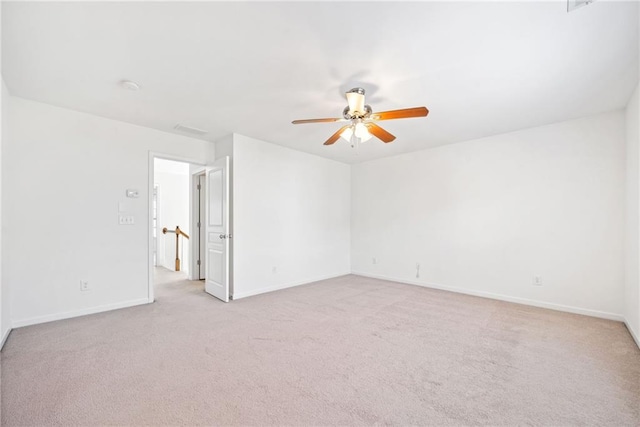 unfurnished room featuring baseboards, a ceiling fan, and light colored carpet