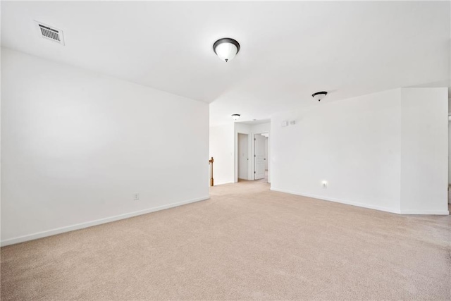 unfurnished room with visible vents, light carpet, and baseboards