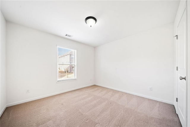 empty room with light colored carpet, visible vents, and baseboards