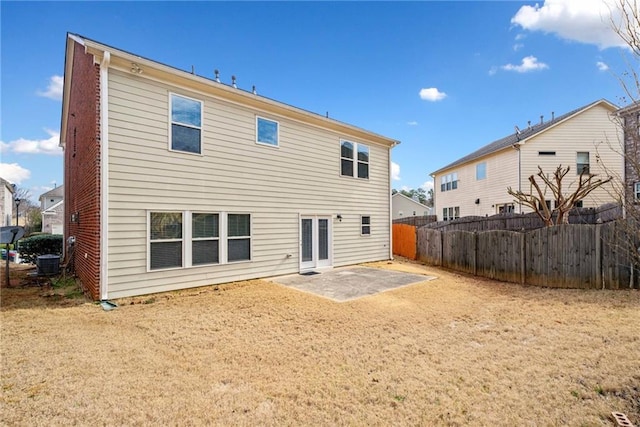 rear view of property with cooling unit, fence, a patio, and brick siding