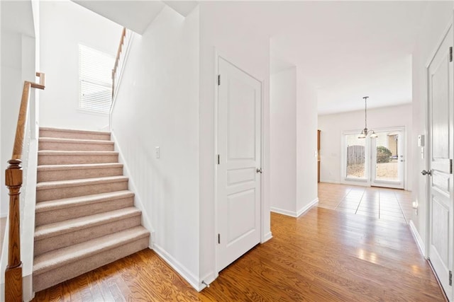 staircase featuring wood finished floors and baseboards