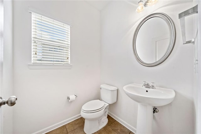 bathroom featuring tile patterned flooring, toilet, and baseboards