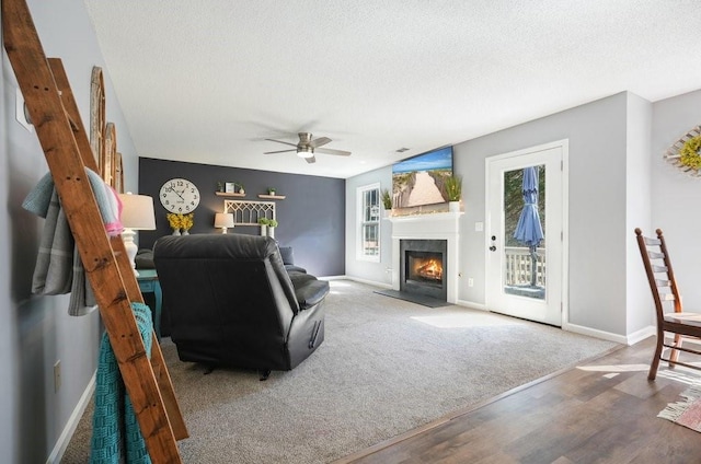 537 Autumn Ridge Dr, Canton, GA 30115 - living room with a fireplace with flush hearth, a textured ceiling, baseboards, a ceiling fan, and wood finished floors