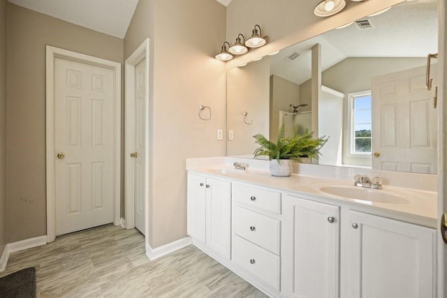 537 Autumn Ridge Dr, Canton, GA 30115 - bathroom with double vanity, wood finished floors, baseboards, vaulted ceiling, and a shower