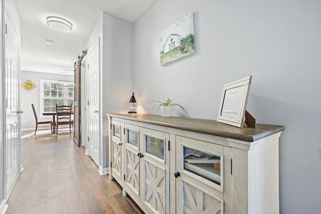 537 Autumn Ridge Dr, Canton, GA 30115 - hallway with light wood-style flooring, a textured ceiling, and baseboards