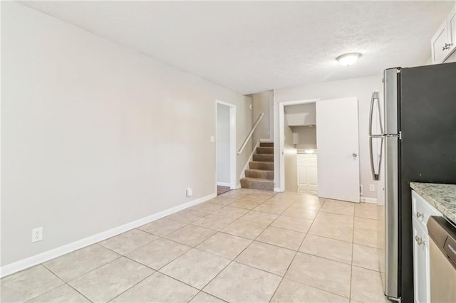 6071 Cristie Dr, Ellenwood, GA 30294 - kitchen featuring stainless steel appliances, light tile patterned flooring, baseboards, white cabinetry, and a textured ceiling