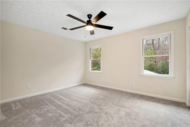 carpeted empty room with ceiling fan and a textured ceiling