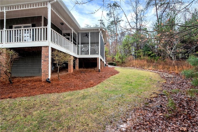 back of house featuring ceiling fan, a yard, and a sunroom