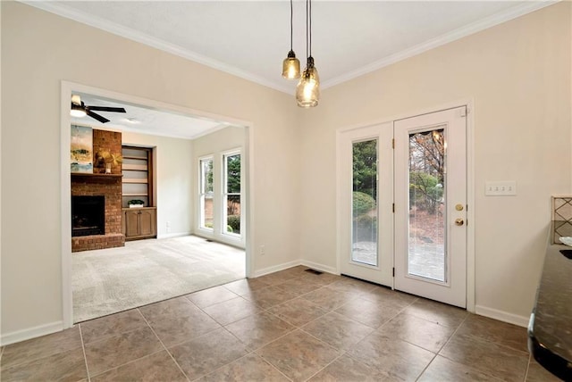 doorway to outside featuring built in shelves, ornamental molding, carpet, and a brick fireplace