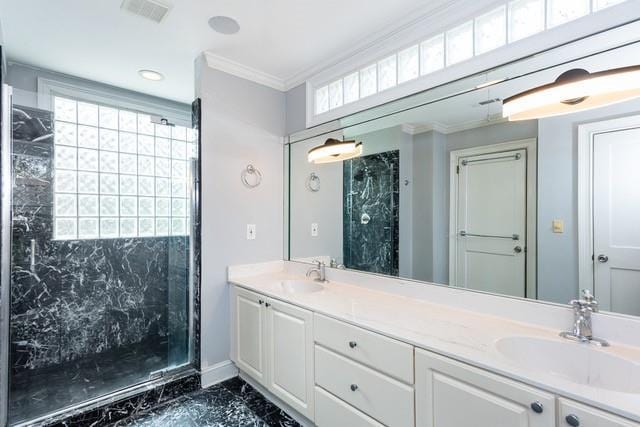 full bath featuring a marble finish shower, visible vents, ornamental molding, double vanity, and a sink