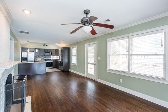 kitchen featuring visible vents, a peninsula, ornamental molding, stainless steel appliances, and light countertops