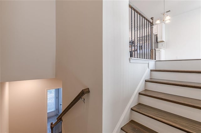 stairway featuring a chandelier