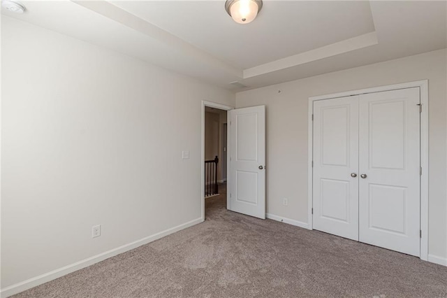 unfurnished bedroom featuring light carpet and a closet