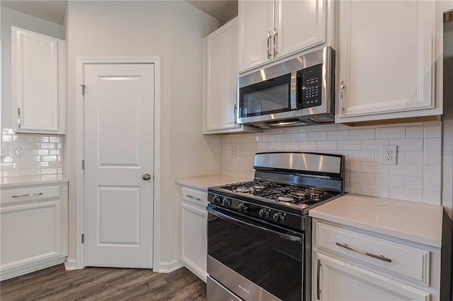 kitchen featuring backsplash, white cabinets, stainless steel appliances, and dark hardwood / wood-style floors