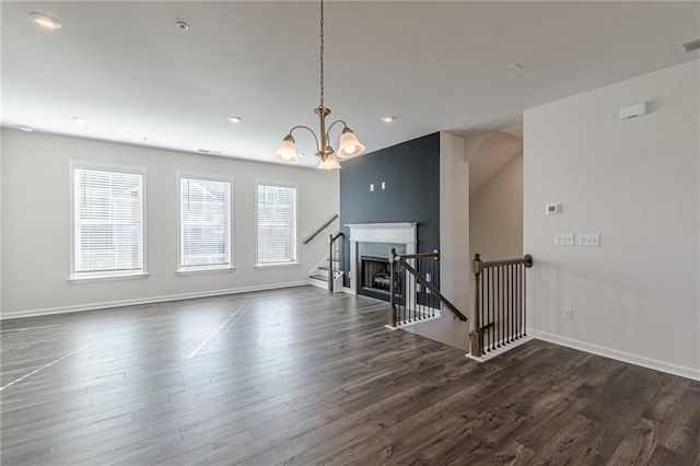 unfurnished living room with dark hardwood / wood-style floors and a notable chandelier