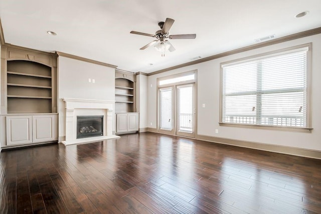 1435 Druid Mnr, Atlanta, GA 30329 - unfurnished living room featuring a glass covered fireplace, ceiling fan, crown molding, built in features, and dark wood finished floors