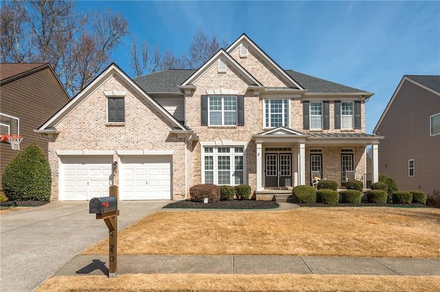 view of front of house featuring a front yard, a garage, brick siding, and driveway