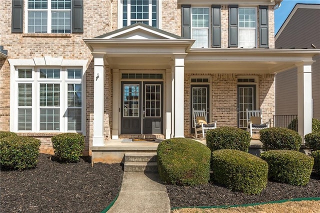 entrance to property with brick siding and covered porch