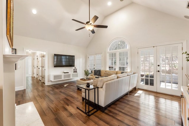 living room with dark wood-type flooring, high vaulted ceiling, french doors, and ceiling fan