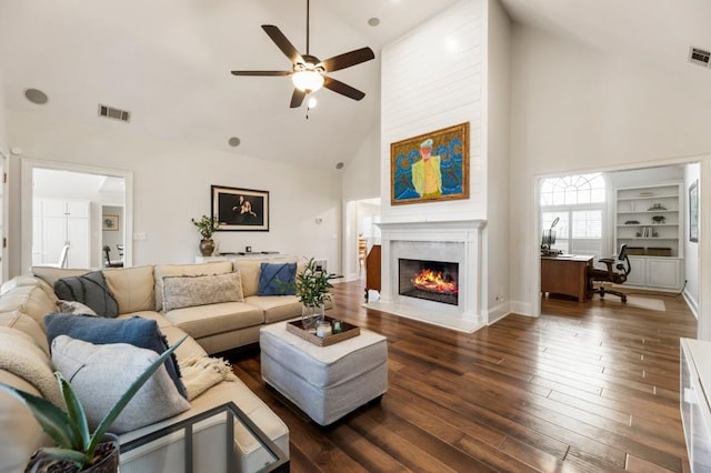 living room featuring ceiling fan, high vaulted ceiling, built in features, and dark hardwood / wood-style flooring