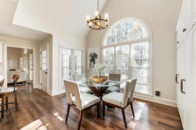 dining space featuring dark wood-type flooring, high vaulted ceiling, and a chandelier