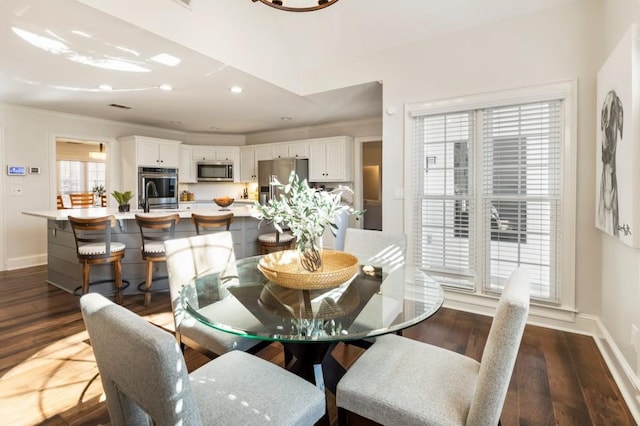 dining area featuring ornamental molding, dark hardwood / wood-style floors, and sink