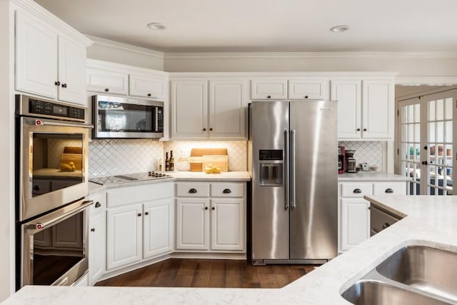 kitchen featuring stainless steel appliances, light stone countertops, and white cabinets