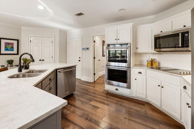 kitchen with stainless steel appliances, dark hardwood / wood-style floors, sink, and white cabinets