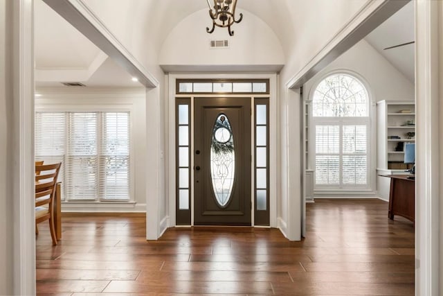 foyer featuring dark hardwood / wood-style floors, a chandelier, and vaulted ceiling