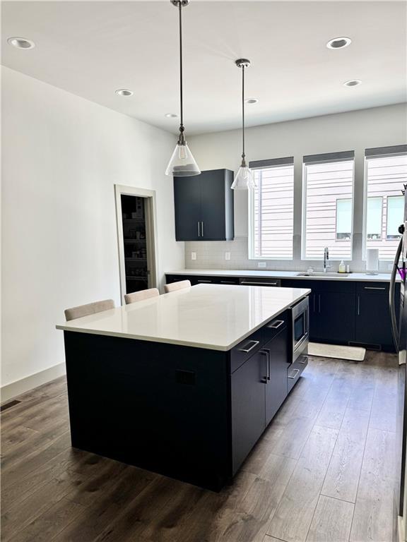 1153 Reynolds Square Ln # 16, Atlanta, GA 30307 - kitchen featuring dark cabinetry, light countertops, a sink, a kitchen island, and recessed lighting