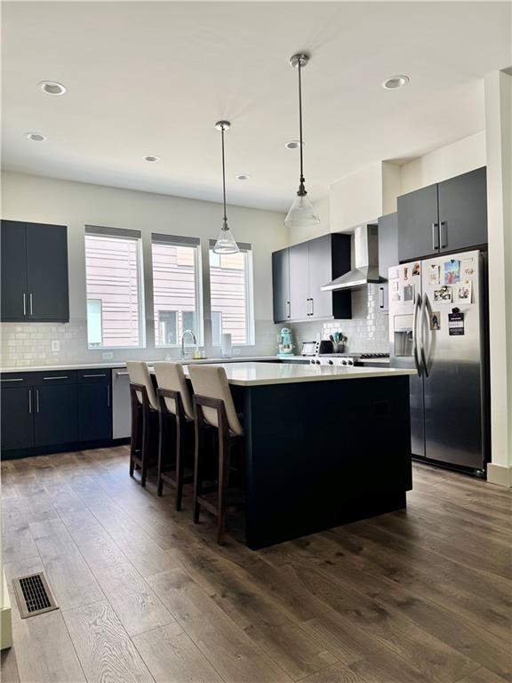 1153 Reynolds Square Ln # 16, Atlanta, GA 30307 - kitchen with stainless steel fridge, wall chimney exhaust hood, light countertops, tasteful backsplash, and recessed lighting