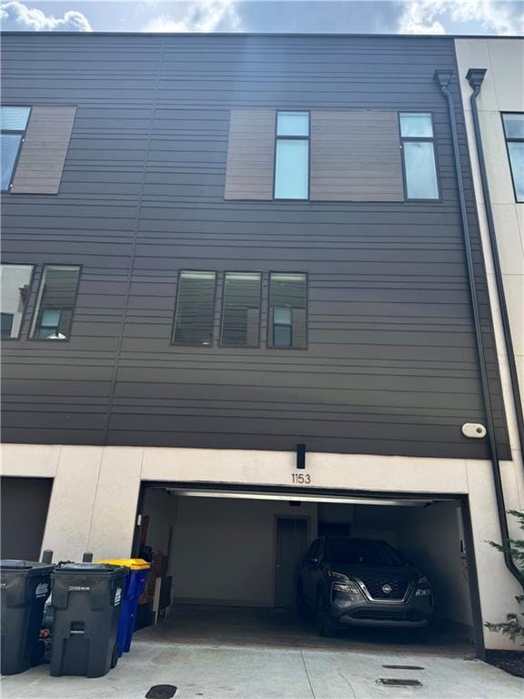 1153 Reynolds Square Ln # 16, Atlanta, GA 30307 - view of property exterior featuring an attached garage, driveway, and stucco siding