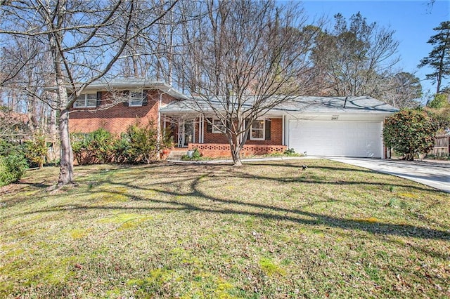 tri-level home with a garage, driveway, brick siding, and a front yard