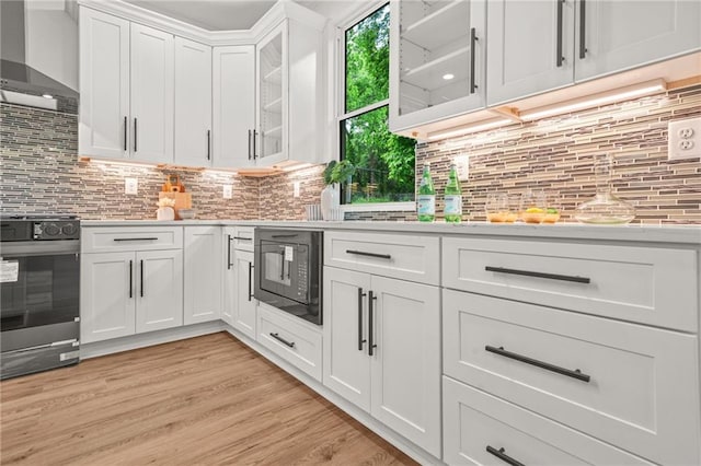 2926 5th St SW, Atlanta, GA 30315 - kitchen featuring stainless steel range with electric stovetop, wall chimney exhaust hood, black microwave, light countertops, and white cabinets