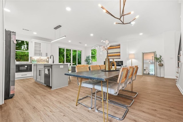 2926 5th St SW, Atlanta, GA 30315 - dining room featuring light wood finished floors, a chandelier, recessed lighting, and baseboards