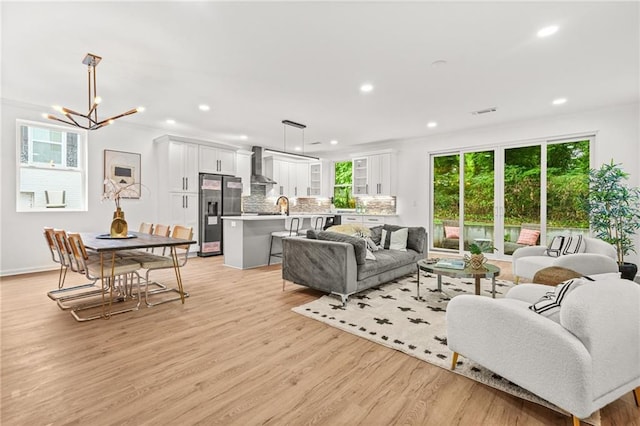 2926 5th St SW, Atlanta, GA 30315 - living room featuring light wood-style flooring, recessed lighting, a chandelier, and baseboards