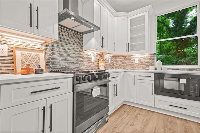 2926 5th St SW, Atlanta, GA 30315 - kitchen with stainless steel range with gas cooktop, wall chimney range hood, light countertops, and black microwave
