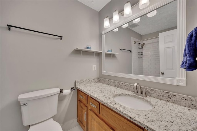 bathroom with a shower, vanity, and toilet