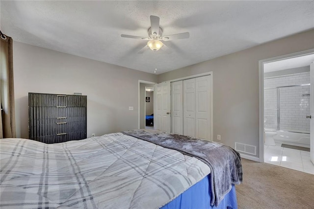 bedroom with a closet, a textured ceiling, ensuite bath, visible vents, and carpet floors