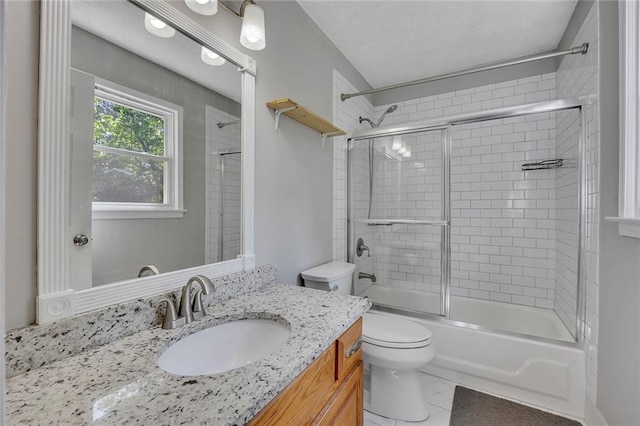 full bathroom featuring toilet, tile patterned floors, vanity, and enclosed tub / shower combo