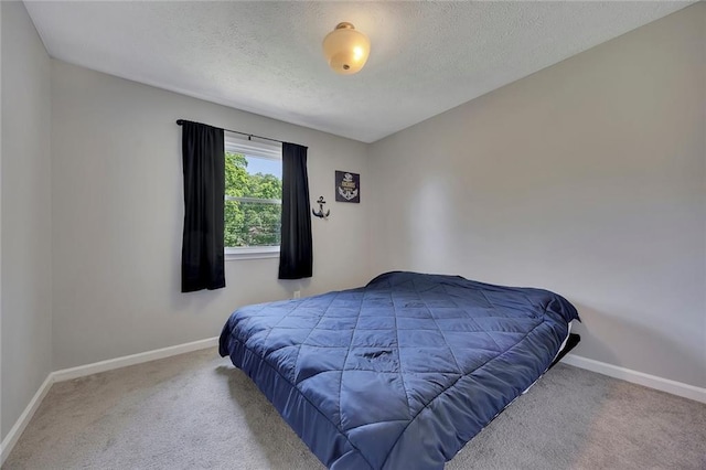 bedroom featuring baseboards, carpet flooring, and a textured ceiling